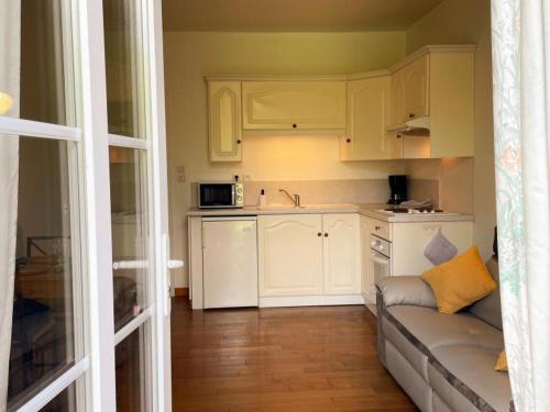 un salon avec un canapé et une cuisine dans l'établissement Gîte cosy avec terrasse privative, parking et WiFi - FR-1-491-443, à Saint-Claude-de-Diray