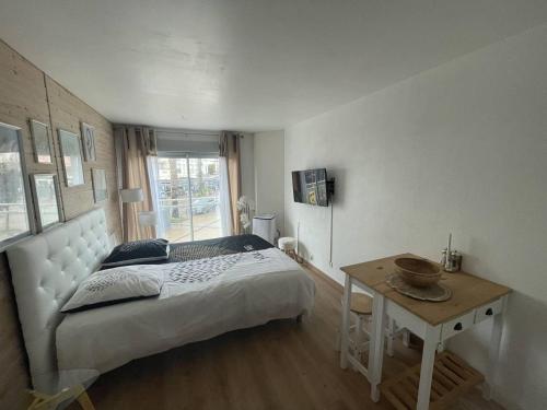 une chambre avec un grand lit et une table dans l'établissement Studio rénové au centre port, à 2 min des commodités et proche plage - FR-1-723-154, au Cap d'Agde