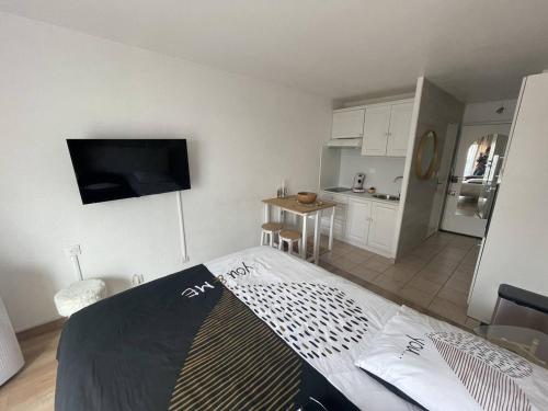 une chambre avec un lit et une petite cuisine dans l'établissement Studio rénové au centre port, à 2 min des commodités et proche plage - FR-1-723-154, au Cap d'Agde