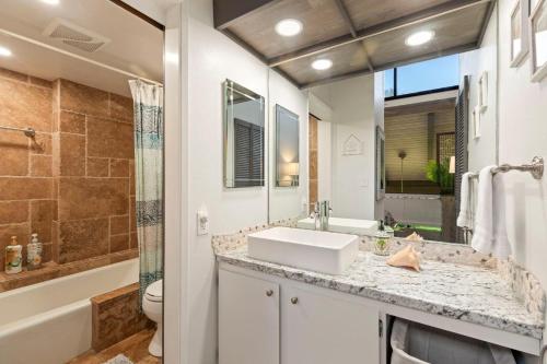 a bathroom with a sink and a toilet and a tub at Luana Kai Loft C308 BY Betterstay in Kihei