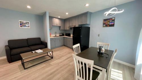 a kitchen and a living room with a table and a couch at Quintessence ApartHotel in Los Angeles