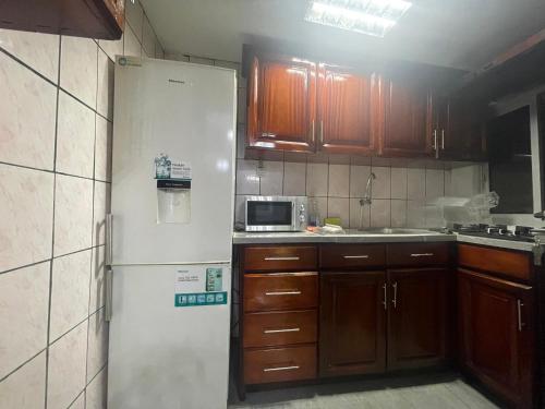 eine Küche mit einem weißen Kühlschrank und Holzschränken in der Unterkunft Danin Real-estates in Douala