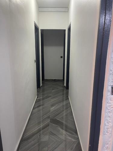 un pasillo con paredes blancas y suelo de madera en Danin Real-estates en Duala