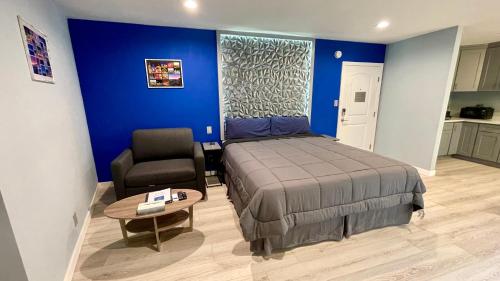 a bedroom with a bed and a chair and a table at Quintessence ApartHotel in Los Angeles