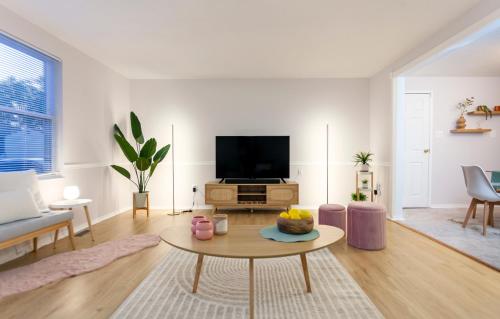 a living room with a tv and a table at Metropolitan Splendor in Fort Washington