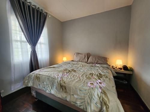 Porlak Hebron Family Homestay في Siborongborong: غرفة نوم بسرير ونافذة