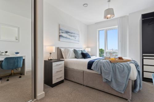 een slaapkamer met een bed, een bureau en een spiegel bij Luxury Birmingham city centre apartment in Birmingham