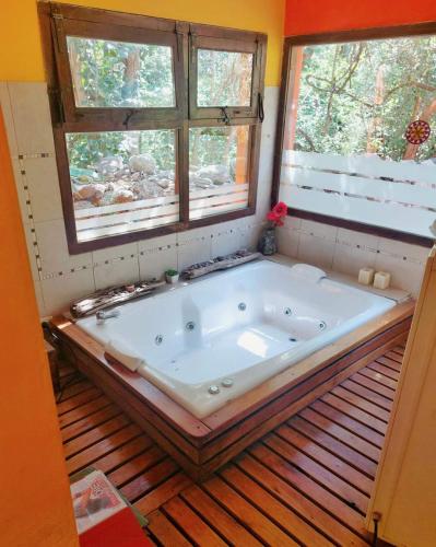 a large bath tub in a room with two windows at Cabañas spa el petrel in San Javier