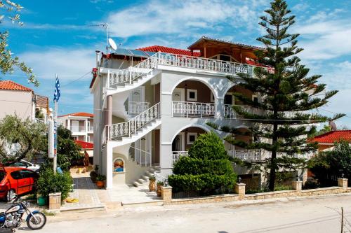 a white building with a christmas tree in front of it at Amoudi Studios Apartments Hotel in Amoudi