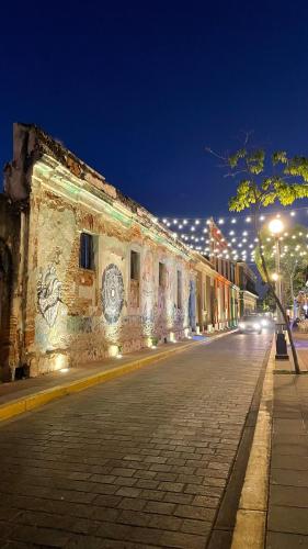 an old building with lights on a street at night at Casa Alicia @ Downtown in Mazatlán