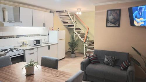 Una sala de estar con un sofá y una mesa y una cocina. en La Estepa, en Las Heras