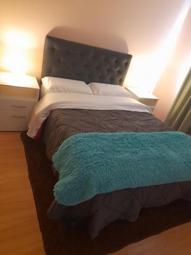 Un dormitorio con una cama con una manta azul encima. en La Estepa, en Las Heras