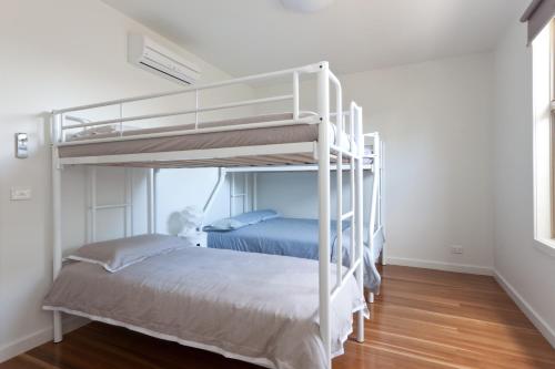 Cette chambre blanche dispose de 2 lits superposés et de parquet. dans l'établissement Taworri, à Queenscliff