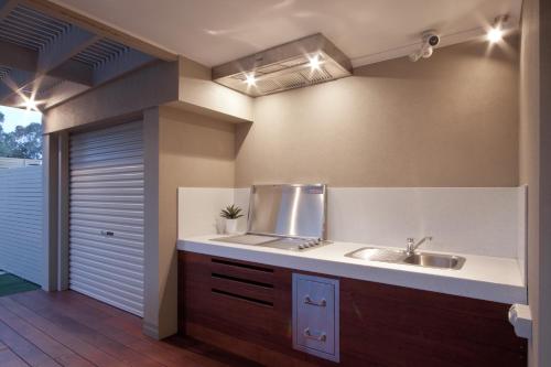 uma cozinha com um lavatório e uma bancada em Taworri em Queenscliff