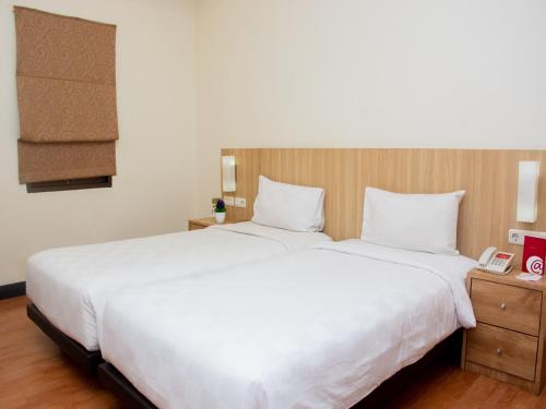 duże białe łóżko w pokoju hotelowym w obiekcie @Hom Premiere by Horison Abepura w mieście Abepura