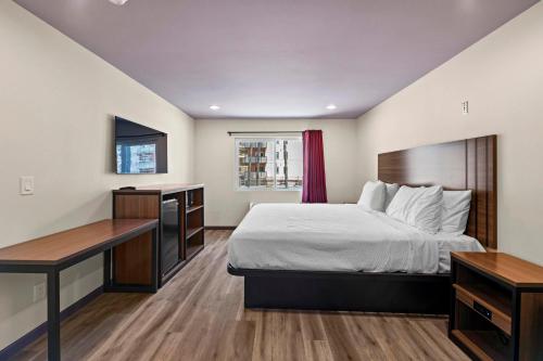 a hotel room with a bed and a desk at Hyland Inn Long Beach in Long Beach