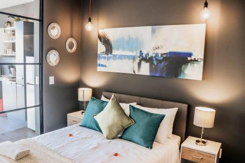 Schlafzimmer mit einem Bett mit blauen und weißen Kissen in der Unterkunft Modern Wex 831 in Kapstadt