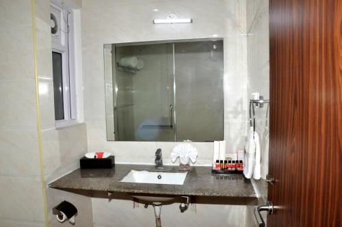 a bathroom with a sink and a mirror at Triguna Clarks Inn Kurnool in Kurnool