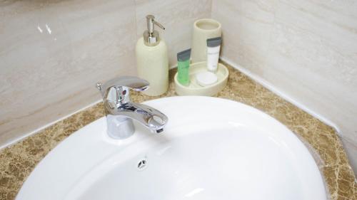 a white sink with a faucet in a bathroom at Amazing Studio Apartments Zc in Abu Dhabi