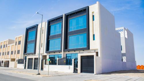 a large building with blue windows on a street at Amazing Studio Apartments Zc in Abu Dhabi
