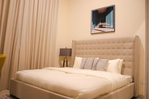 a bedroom with a large bed with white sheets at Amazing Studio Apartments Zc in Abu Dhabi