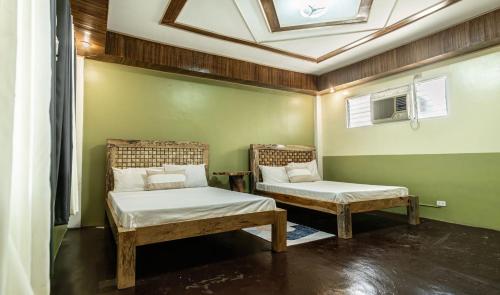 2 łóżka w pokoju z sufitem w obiekcie One Alo Hotel and Resort by Hiverooms w mieście Manaoag
