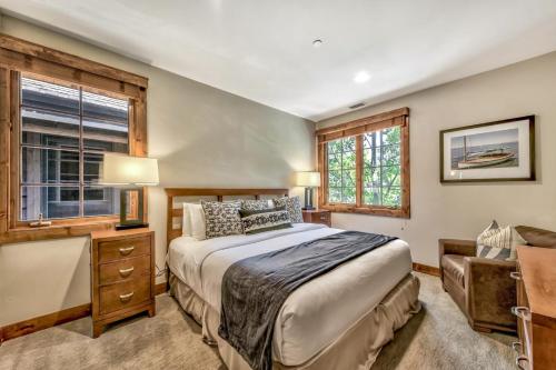 a bedroom with a bed and a desk and windows at The PEAK Aconcagua 6 - The Ultimate in Lakefront Luxury in South Lake Tahoe