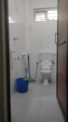 a bathroom with a toilet and a blue bucket at Vosu Homestay in Dimāpur