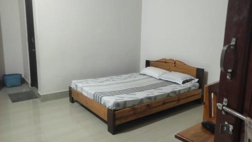1 dormitorio con cama de madera en una habitación en Vosu Homestay, en Dimāpur