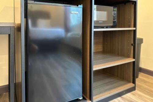 a refrigerator in a cabinet with a microwave at Hyland Inn Long Beach in Long Beach