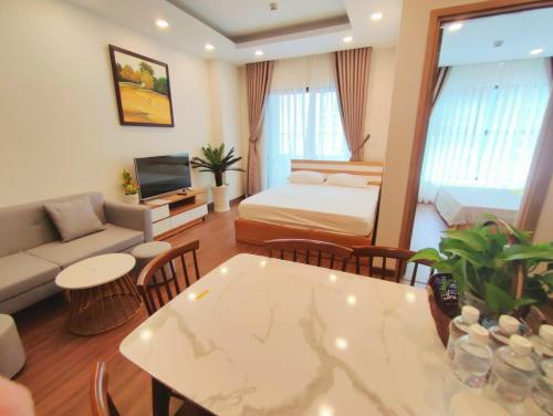 Sala de estar con cama, sofá y mesa en FLC Sea Tower Quy Nhơn - Codotel Cạnh Biển Quy Nhơn, en Quy Nhon