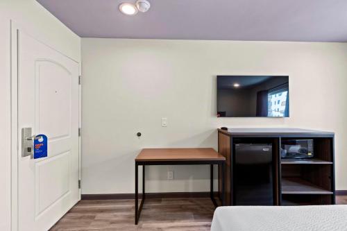 a room with a table and a tv on a wall at Hyland Inn Long Beach in Long Beach