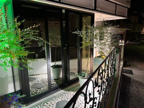 uma varanda com portas de vidro e vasos de plantas em Halvat Guesthouse em Sarajevo