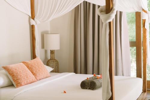 a bedroom with a white bed with a canopy at Villa Sorgas in Kuta Lombok