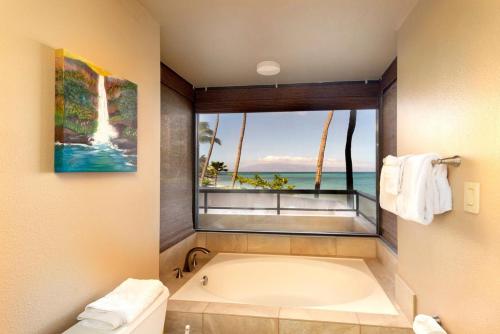 Oceanfront corner unit w/ ac! sk215- Sullivan في Kahana: حمام مع حوض استحمام ونافذة