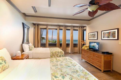 1 dormitorio con 2 camas y ventilador de techo en Oceanfront corner unit w/ ac! sk215- Sullivan en Kahana
