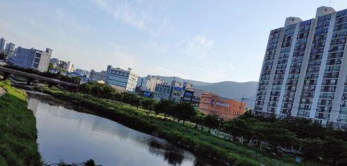 une rivière dans une ville avec de grands bâtiments dans l'établissement Moslim friendly guest house, à Yangsan