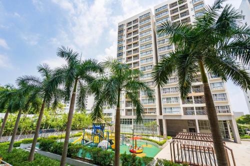 a building with palm trees in front of a playground at Scenic valley Serviced Apartment in Ho Chi Minh City