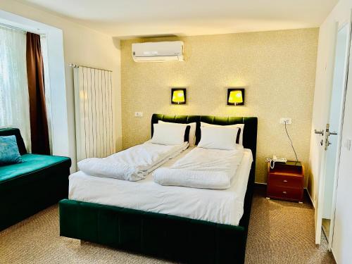 Schlafzimmer mit einem großen Bett mit einem grünen Kopfteil in der Unterkunft Halvat Guesthouse in Sarajevo