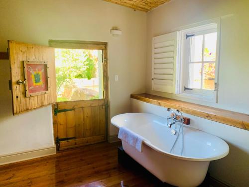a bathroom with a white tub and a window at Vergeet-My-Niet in Prince Albert