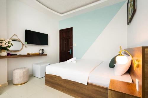Habitación de hotel con cama y TV en Vivianne Boutique Hotel, en Ho Chi Minh