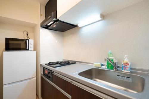 a kitchen with a sink and a refrigerator at Best Residence Kujo in Osaka