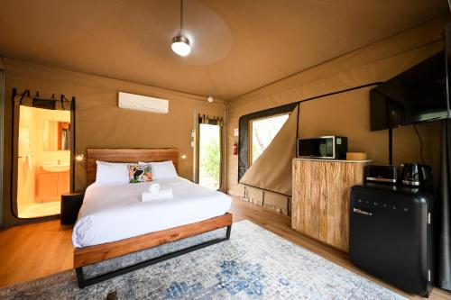 1 dormitorio con 1 cama y TV. en Belair National Park Holiday Park en Belair