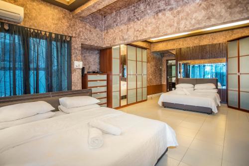 a bedroom with two beds in a room with windows at Zoo Villa by Cobnb at Zoo Negara, Ampang Area in Ampang