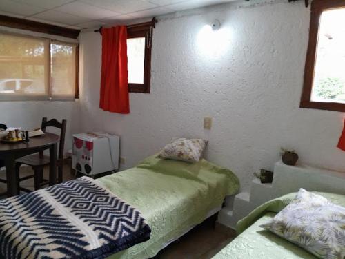 a bedroom with two beds and a table and window at Architerra in San Javier