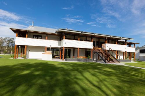 a large house with a lawn in front of it at Neat Acres Farmhouse in Darawank