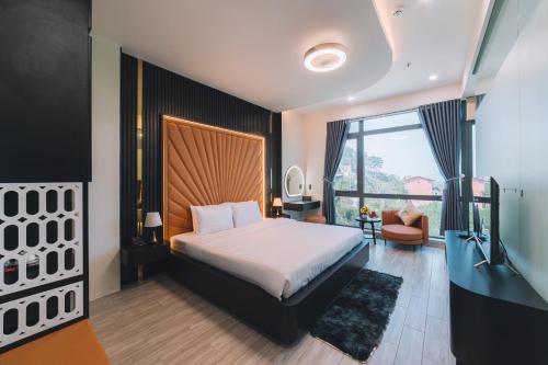 a bedroom with a bed and a large window at Greenview Hotel DaLat in Da Lat