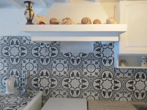 a kitchen with a black and white patterned wall at Alex oldtown sea view rooms and appartments in Mýkonos City