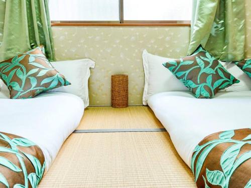 a room with two beds with pillows at 鯉 in Osaka