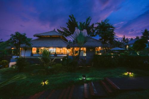 a house with lights in front of it at night at Medewi Bay Retreat in Pulukan